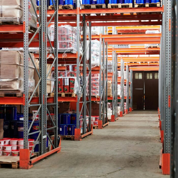 Industrial warehouse interior with organized shelves stacked with packages and goods.
